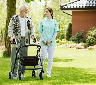Nurse and patient in the garden of modern senior home with daily care